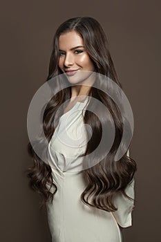 Pretty woman wearing white dress smiling on brown background