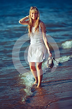 Pretty woman in a white dress on the ocean coast