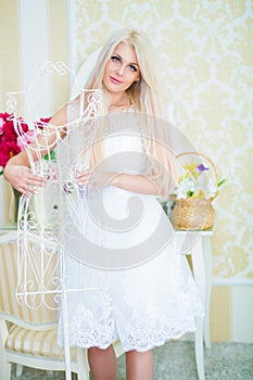 Pretty woman in white dress touches white hanger photo