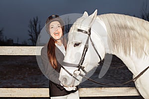 Pretty woman and white horse having fun outdoor