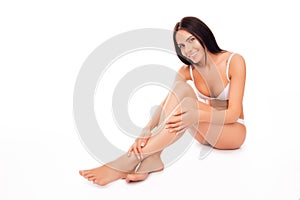 Pretty woman in white underwear doing massage for her legs