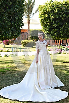 Pretty woman in white wedding dress, fashionable makeup and hair