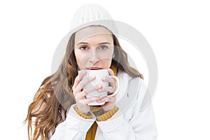 Pretty woman in winter clothes drinking a hot beverage