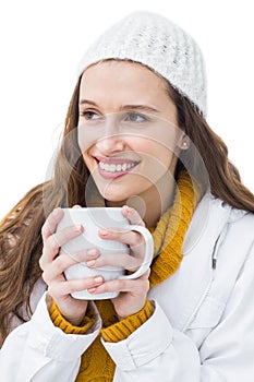 Pretty woman in winter clothes drinking a hot beverage