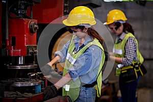 Pretty woman workers or technician are working with machine in factory