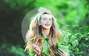 Pretty woman working and playing in beautiful garden. Spring woman fashion concept. Portrait of smiling charming girl
