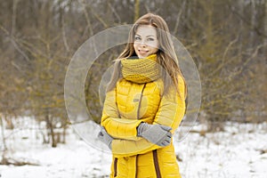 Pretty woman in a yellow knit scarf. Outdoor portrait in the par