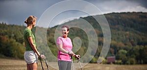 Pretty, women nordic walking on a forest path, taking in t