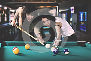 Pretty women playing billiards