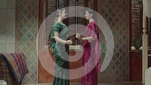 Pretty women in sari meeting and greeting each other