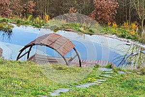 Pretty wooden pier at natural swimming pond purifying water plants