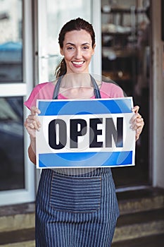 Pretty worker showing open sign