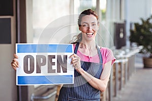 Pretty worker showing open sign