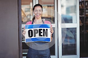 Pretty worker showing open sign