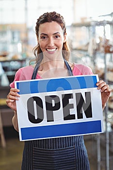 Pretty worker showing open sign