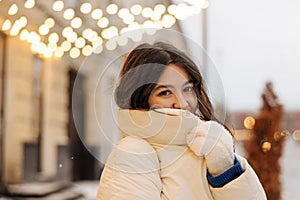 Pretty youg caucasian woman looking at camera with smile spends time at european street.