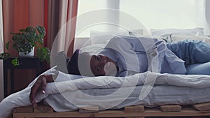 Pretty Young African American Woman Waking Up In Bed and looking at the camera