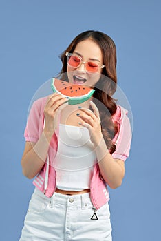 Pretty young Asian woman with juicy watermelon on color blue background