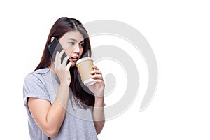 Pretty young asian woman standing isolated on white background. Beautiful girl in gray casual shirt with phone and takeaway coffee