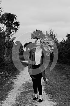 Pretty Young Beauty Woman Model with Gorgeous Long Blond Hair Blowing in the Wind Smiling for Portrait Shots Outside at the Park