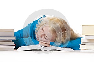 Pretty young blond schoolgirl sleeps on schoolbook