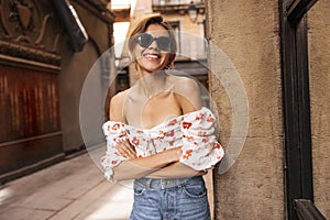 Pretty young blonde caucasian woman smiles teeth at camera walking around city during day.