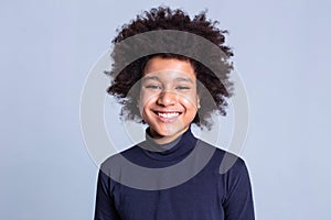 Pretty young boy with wide smile having African hairstyle