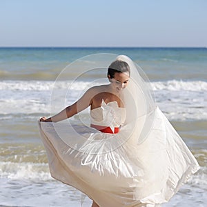 Pretty young bride walking on a beach