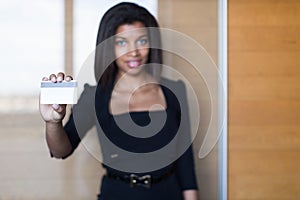 Pretty, young business lady in black strong suite hold visit card