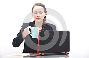 Pretty young business woman drinking coffee at work