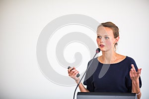 Pretty, young business woman giving a presentation in a conference/meeting setting