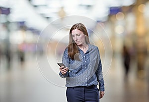 Pretty young business woman talking to mobil phone over blur background