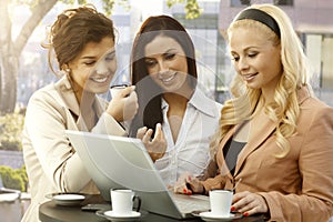 Pretty businesswomen using laptop outdoors photo