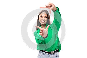pretty young caucasian brunette lady with makeup dressed in a green shirt and jeans posing on a white background with