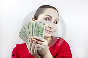 Pretty young caucasian brunette woman in casual red dress holding american dollars in her hands. Finance and money concept
