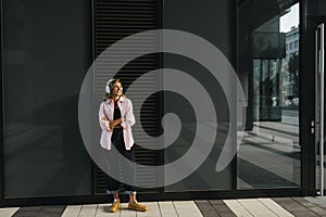 Pretty young caucasian girl looking away with her arms crossed standing outdoors.