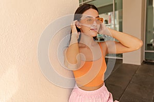 Pretty young caucasian model looks away corrects hair during summer morning.