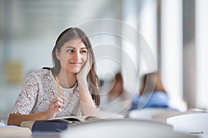 Pretty, young college student looking for a book in the library