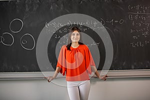 Pretty, young college student/young teacher writing on the chalkboard