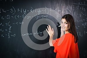 Pretty, young college student/young teacher writing on the chalkboard