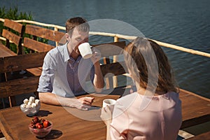 Pretty couple drinking tea outdoors