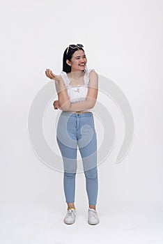 A pretty young extroverted asian woman looking carefree. Full body photo isolated on a white backdrop photo