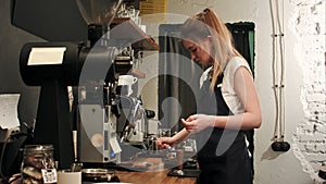 Pretty young female barista weighing coffee grains on a scale before brewing a cup of coffee