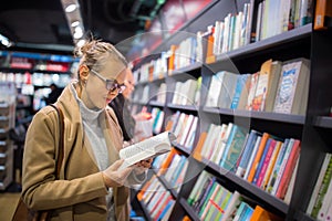 Pretty, young female choosing a good book to buy