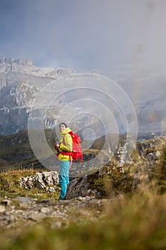 Pretty, young female hiker walking in high mountains