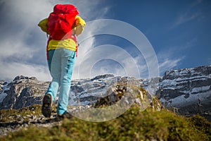 Pretty, young female hiker walking in high mountains