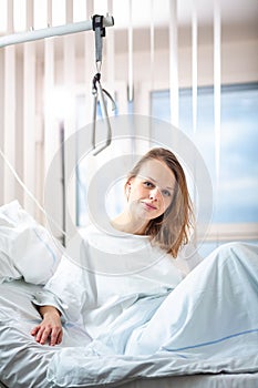Pretty, young, female patient in a modern hospital room