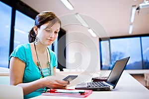 Pretty young female student with laptop