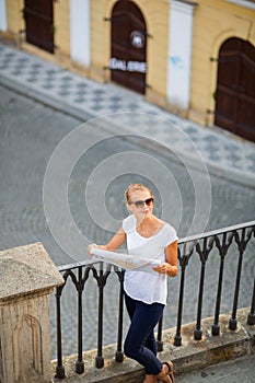 Pretty young female tourist studying a map