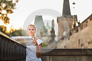 Pretty young female tourist studying a map